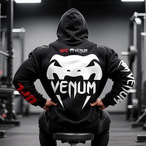 Μαύρο φούτερ ανδρών UFC Venum, πίσω, μοντέλο στο γυμναστήριο, με κουκούλα και λευκή εκτύπωση λογότυπο Venum, κόκκινο UFC