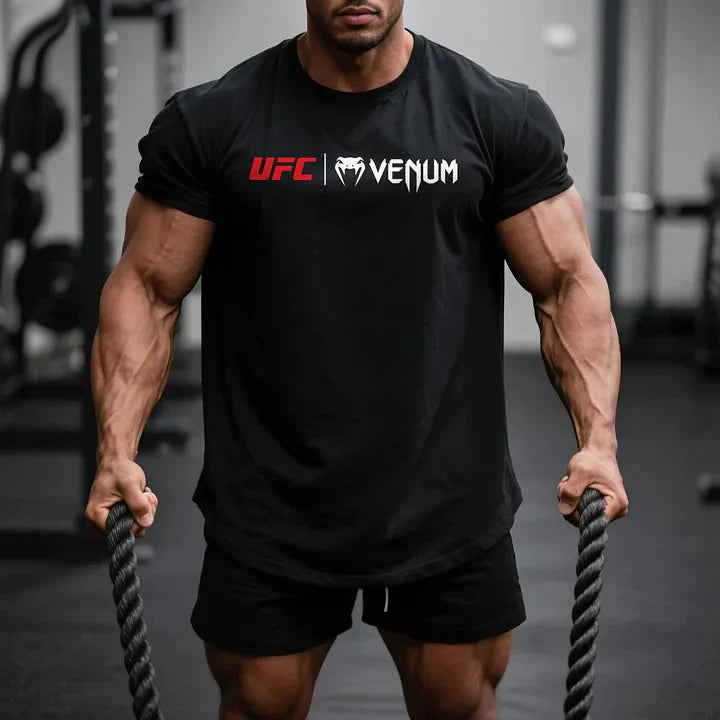Μυώδης άνδρας με μαύρο T-shirt UFC Venum από οργανικό βαμβάκι, με κοντά μανίκια, στο γυμναστήριο